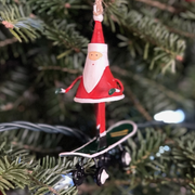 Handmade tin Santa on Skateboard Christmas ornament with a sack of gifts, designed in Denmark and handcrafted in the Philippines.