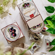 Heindl Rumpflaumen gift cube with individually wrapped dark chocolates filled with whole rum-soaked plums.