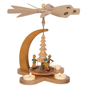 Handcrafted Richard Glässer German Christmas pyramid featuring children skiing through a snowy winter landscape, made in Seiffen, Germany.