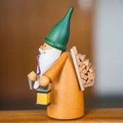 Handcrafted Seiffener Volkskunst Wood Gatherer Gnome incense smoker with a green hat, lantern, firewood backpack and small axe, made in Seiffen, Germany.