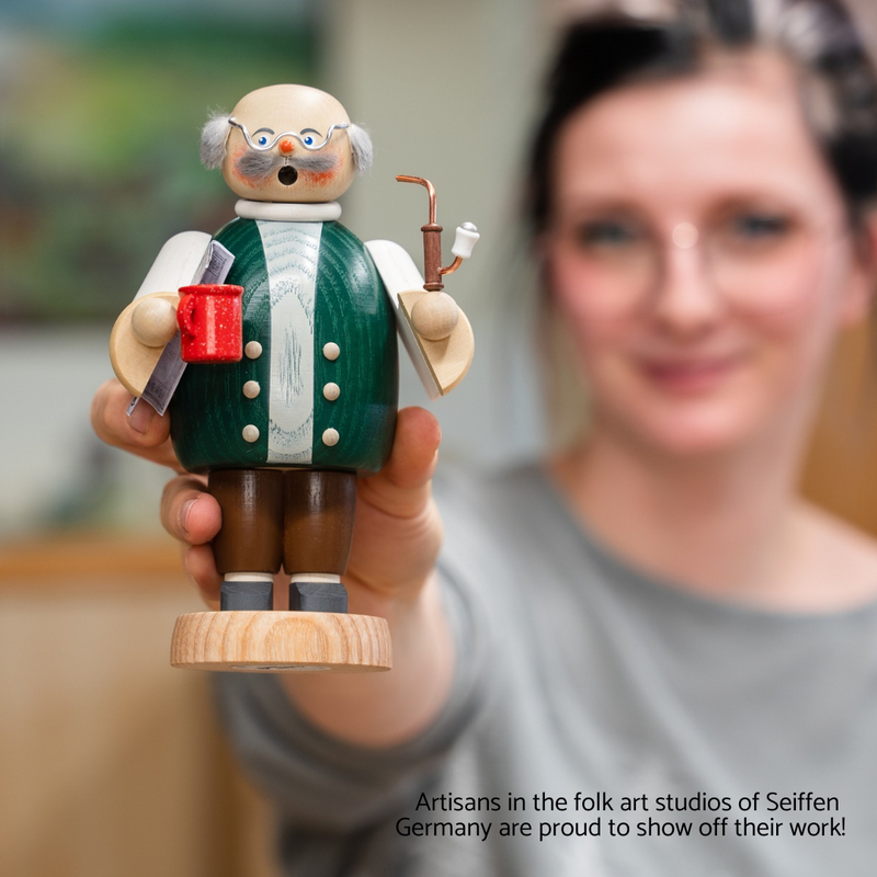 Handcrafted Seiffener Volkskunst Grandfather (Opa) incense smoker holding a coffee mug and newspaper, wearing glasses and a sweater vest, made in Seiffen, Germany.