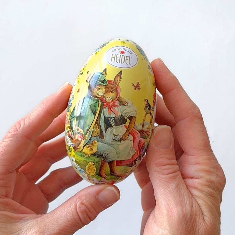 Gingerbread World European Market - Confiserie Heidel Egg-shaped metal gift tin showing front in hands
