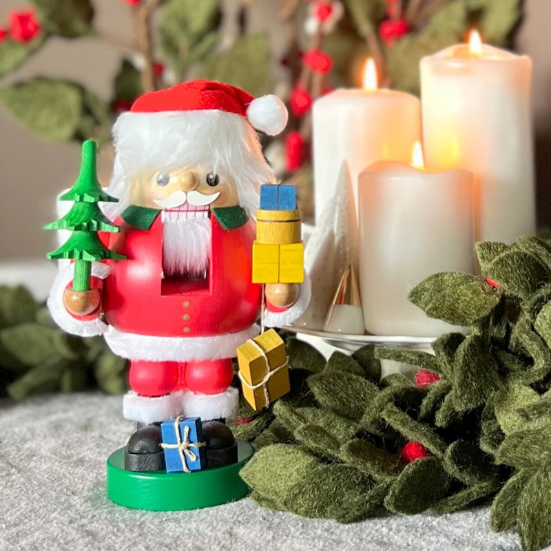 Handcrafted Richard Glässer German Santa Claus nutcracker holding wrapped Christmas gifts, made in Seiffen, Germany.