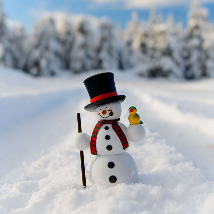 Handcrafted Seiffener Volkskunst Gentleman snowman incense smoker wearing a black top hat, holding a walking stick with a small bird perched on his hand, made in Seiffen, Germany.