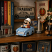 Seiffener Volkskunst limited edition Udo in Trabant German incense smoker displayed on a bookshelf with East German souvenirs including a Trabant sign, Berlin TV Tower, Brandenburg Gate model, DDR memorabilia and history books.