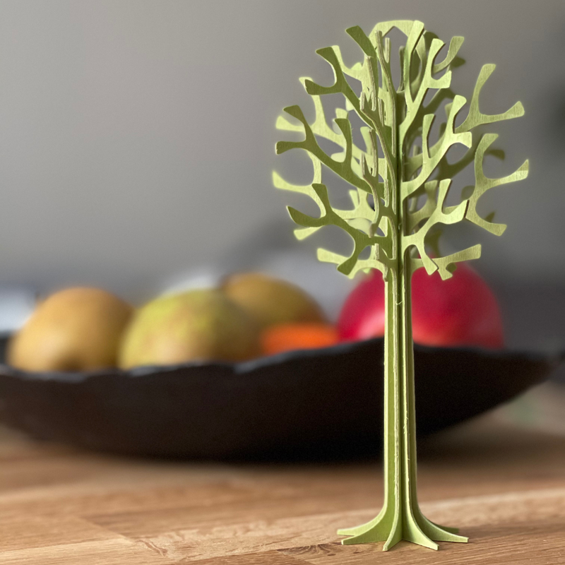 Gingerbread World European Market - Lovi Wooden Creations from the Forests of Finland - 3D wooden Tree 16.5 cm - pale green on table with fruit bowl
